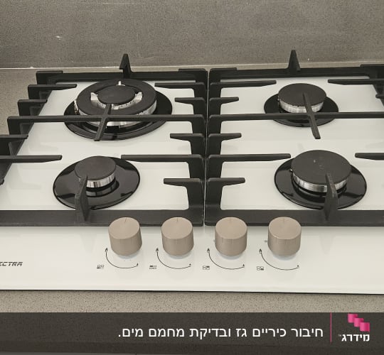 כיריים גז עם ארבעה מבערים וכפתורי שליטה